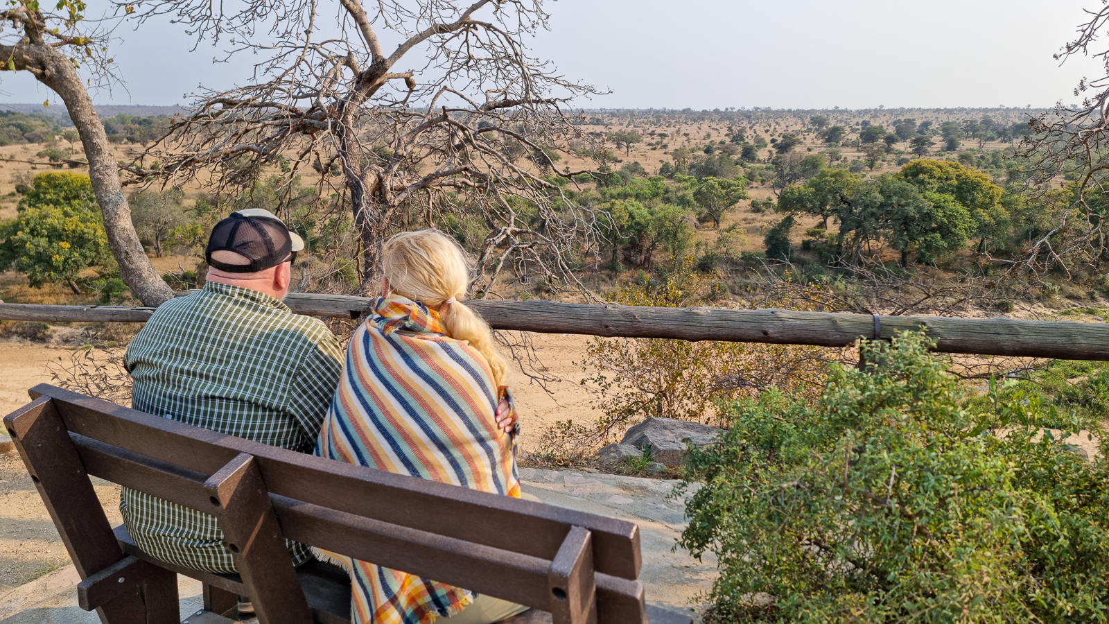 Lovely couple sitting on a bench at a viewpoint in Kruger National Park on safari