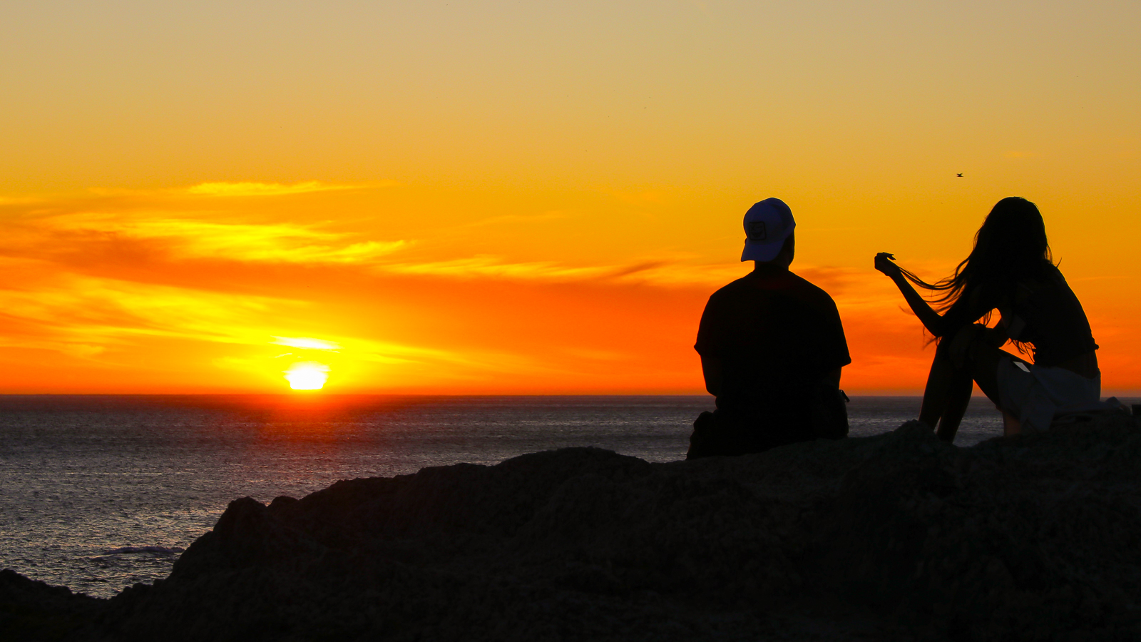 Cape Town tour - Couple enjoying a romantic colourful sunset on Camps Bay in Cape Town
